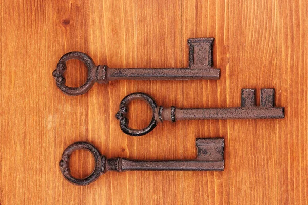Tre chiavi antiche su sfondo di legno — Foto Stock