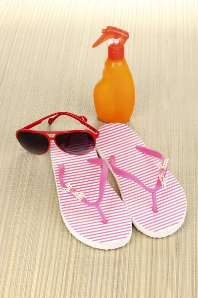 Pembe plaj terlikleri mat güneş kremi ve güneş gözlüğü — Stok fotoğraf