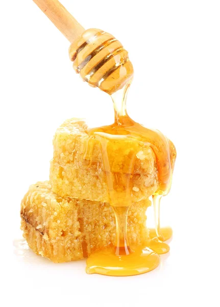 Золотые соты и деревянный дождик с медом, изолированным на белом — стоковое фото