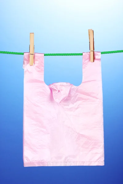 Cellofaan hobbezak die op touw op blauwe achtergrond — Stockfoto