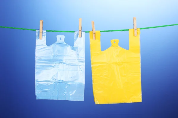 Целофановые мешки висят на веревке на синем фоне — стоковое фото