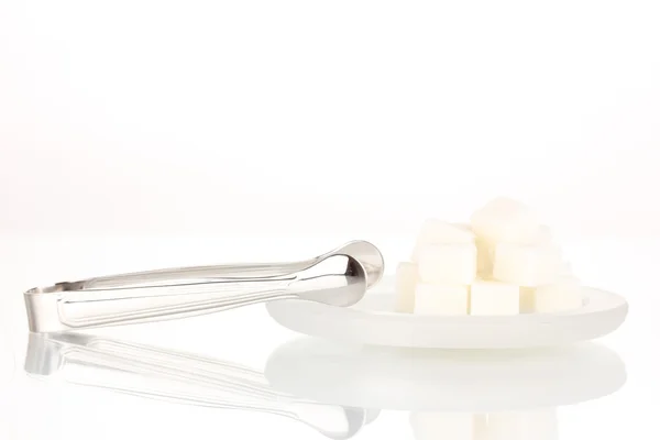 Cubos de azúcar en platillo aislado en blanco — Foto de Stock
