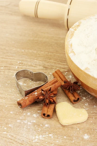 stock image Cutter for biscuits with cinnamon and anise on wooden table close-up