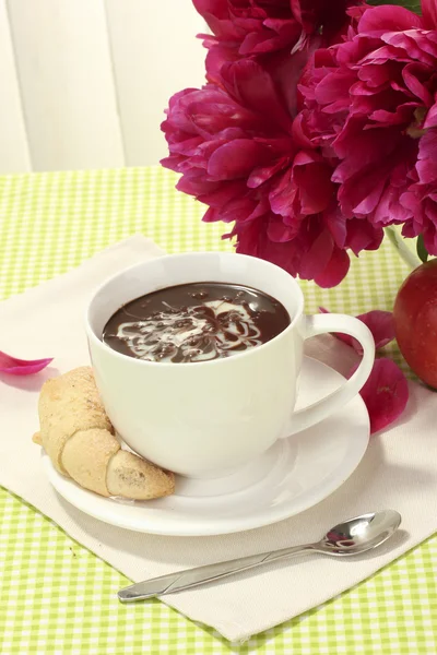 Tasse heiße Schokolade, Apfel, Kekse und Blumen auf dem Tisch im Café — Stockfoto
