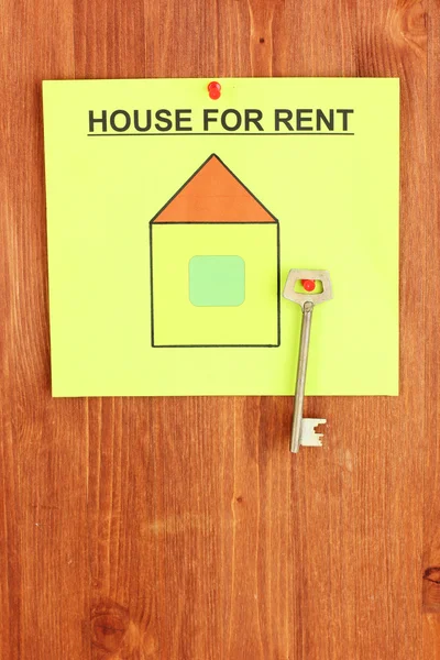 Poster about renting the house with the key on wooden background — Stock Photo, Image
