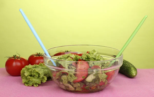Свежий салат с помидорами и огурцами на зеленом фоне — стоковое фото