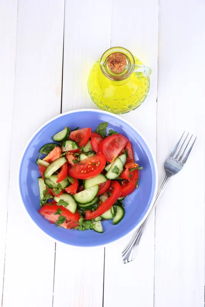 Свіжий салат з помідорами та огірками на білому дерев'яному фоні — стокове фото