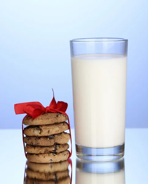 Pohár tej és a cookie-kat a kék háttér — Stock Fotó