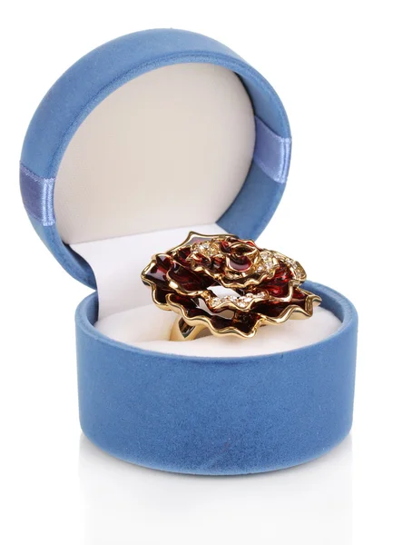 Золотое кольцо с большим красным цветком и прозрачные кристаллы в синей бархатной коробке изолированы на белом — стоковое фото