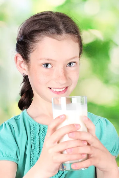 Gyönyörű kis lány withglass tej zöld háttér portréja — Stock Fotó