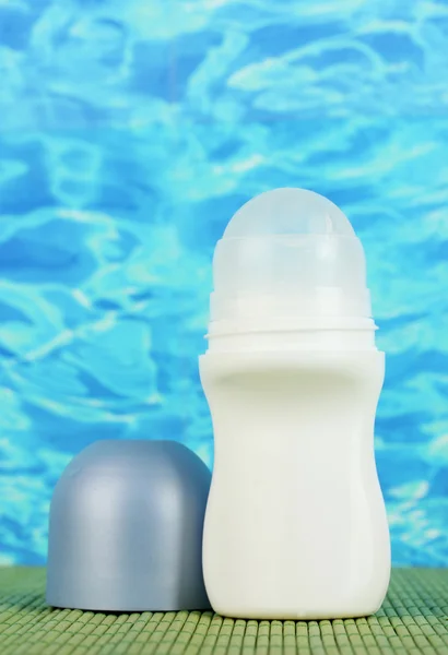 Deodorante e conchiglie su fondo blu marino — Foto Stock