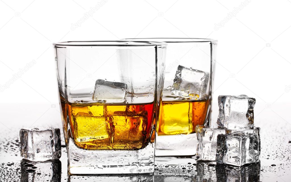 Two glasses of scotch whiskey and ice on table isolated on white