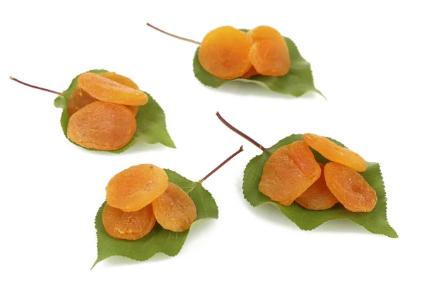 Lahodné sušené meruňky na zelených listech izolovaných na bílém — Stock fotografie