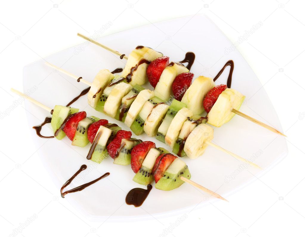 Mixed fruits and berries on skewers with chocolate isolated on white