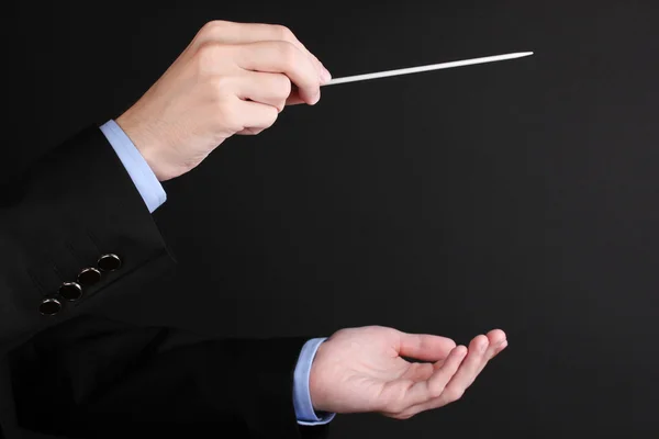 Mãos de maestro de música com bastão isolado em preto — Fotografia de Stock