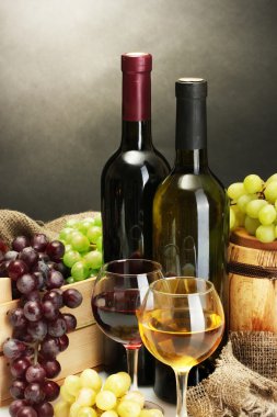 Namlu, şişe ve kadeh şarap ve gri arka plan üzerinde olgunlaşmış üzümler