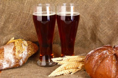 Two glasses of kvass with bread on canvas background close-up clipart