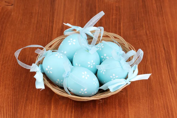 Colorate uova di Pasqua in cesto su sfondo di legno — Foto Stock