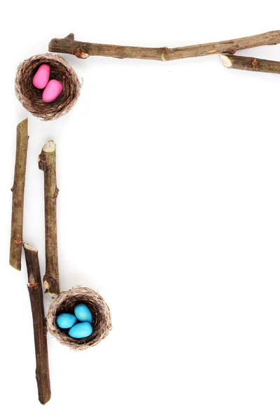 Barevné velikonoční vajíčka v hnízdě izolovaných na bílém — Stock fotografie