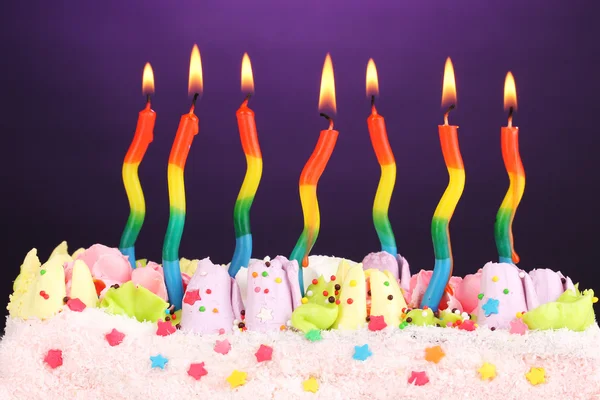Bolo de aniversário com velas no fundo violeta — Fotografia de Stock