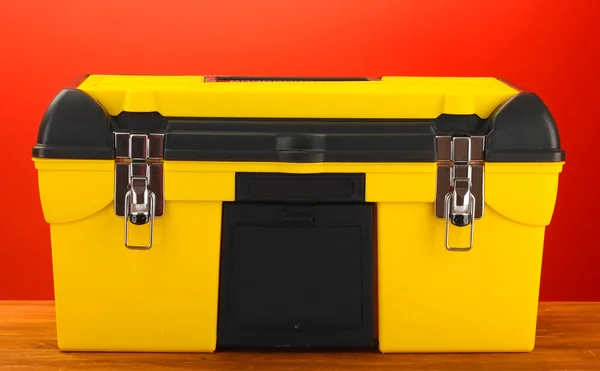 Scatola degli strumenti gialla su sfondo rosso primo piano — Foto Stock