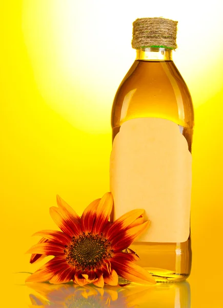 Соняшникова олія та соняшник на жовтому фоні — стокове фото