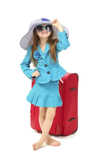 Porträt eines kleinen Mädchens mit Reisetasche, Sonnenbrille und Hut auf weißem Hintergrund — Stockfoto