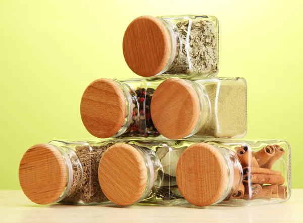 Powder spices in glass jars on green background — Stock Photo, Image