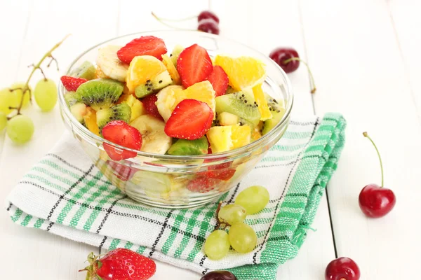 Miska szklana z świeże owoce sałatka i jagody na biały drewniany stół — Zdjęcie stockowe