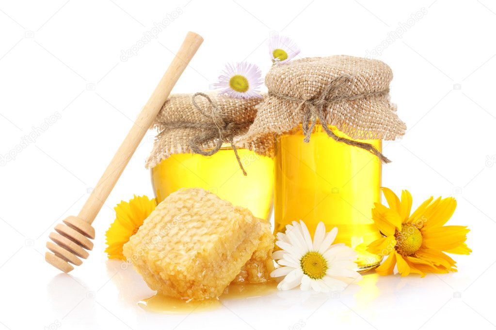 Sweet honey in jars with honeycomb, wooden drizzler and flowers isolated on white
