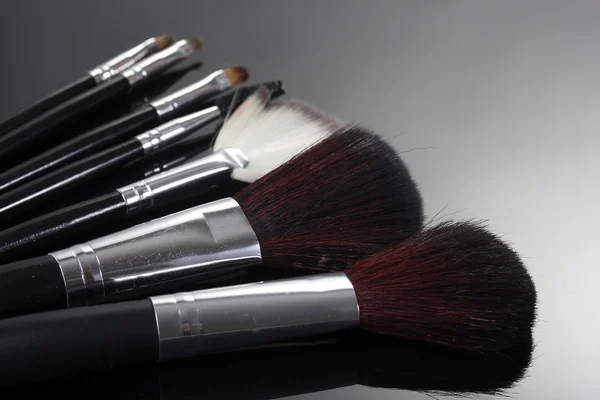 Pinceles de maquillaje sobre fondo gris — Foto de Stock