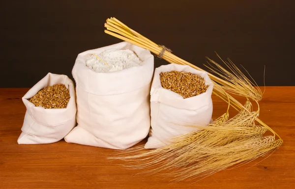 Mouky a pšeničné zrno na dřevěný stůl na tmavém pozadí — Stock fotografie