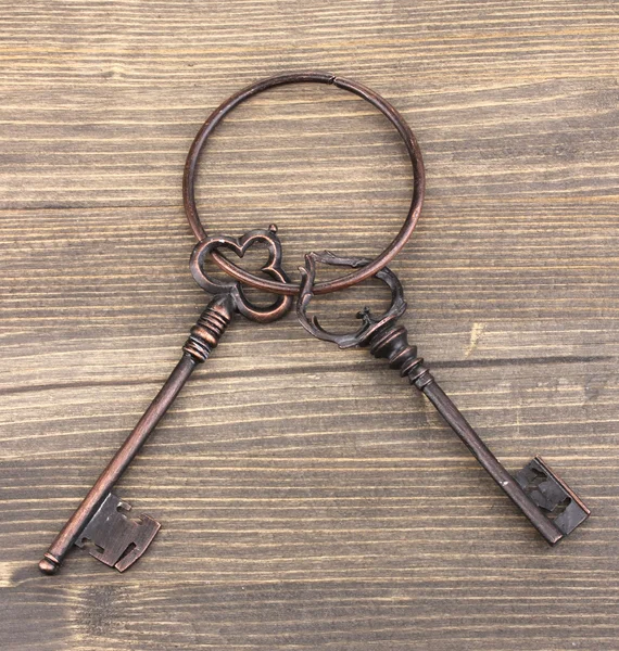 Um monte de chaves antigas em fundo de madeira — Fotografia de Stock