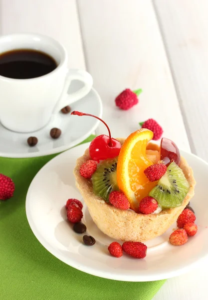 木製のテーブルの上にコーヒーのカップとワンプレートで果物と甘いケーキ — ストック写真