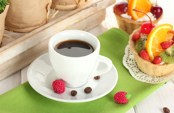 Cup of coffee and sweet cakes with fruits on wooden table — Stock Photo, Image