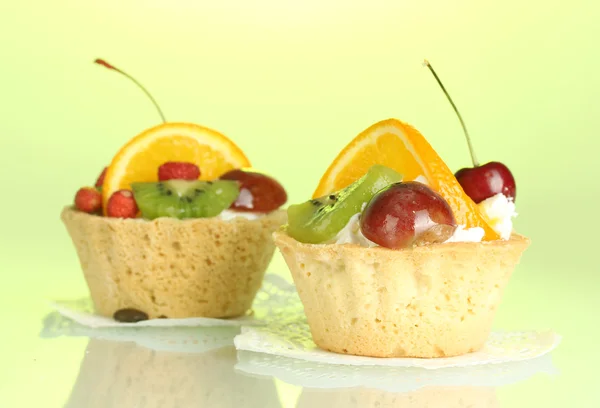 Zoete cake met vruchten op groene achtergrond — Stockfoto