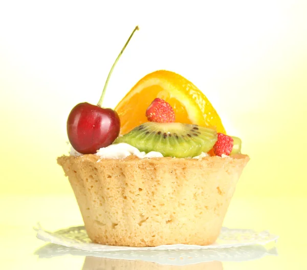 Słodkie ciasto z owocami na żółtym tle — Zdjęcie stockowe