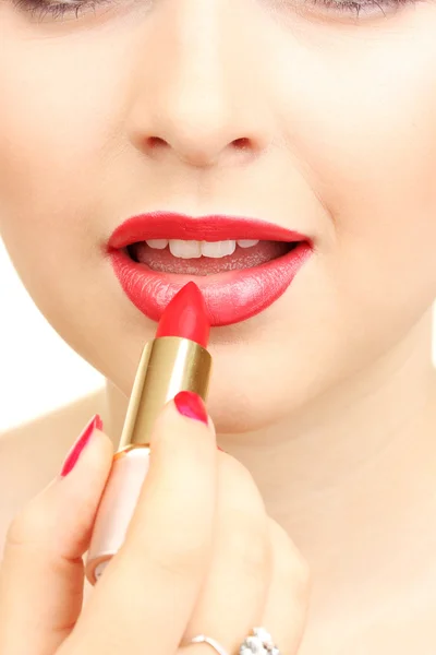 아름다운 여인이 붉은 립스틱으로 입술을 바르고 있다 — 스톡 사진