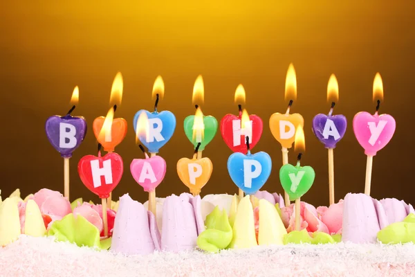 Торт на день рождения со свечами на коричневом фоне — стоковое фото