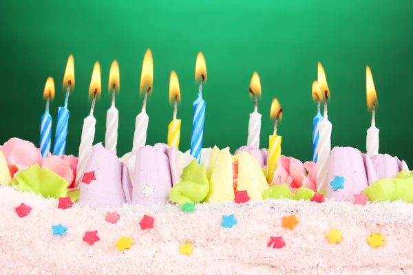 在绿色背景上的蜡烛的生日蛋糕 — 图库照片