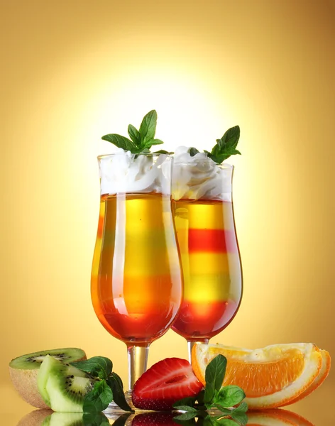 Ζελέ φρούτων στα γυαλιά και τα φρούτα σε κίτρινο φόντο — Φωτογραφία Αρχείου