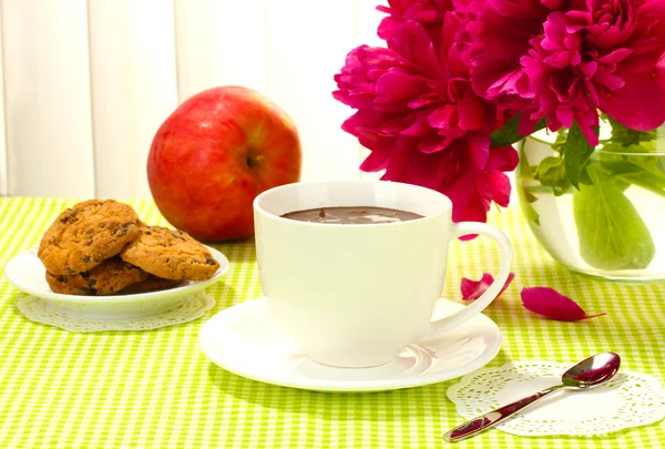 Tasse heiße Schokolade, Apfel, Kekse und Blumen auf dem Tisch im Café — Stockfoto