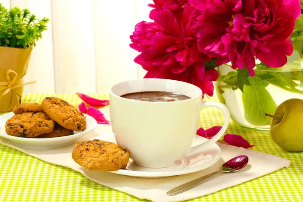 Taza de chocolate caliente, manzana, galletas y flores en la mesa en la cafetería —  Fotos de Stock