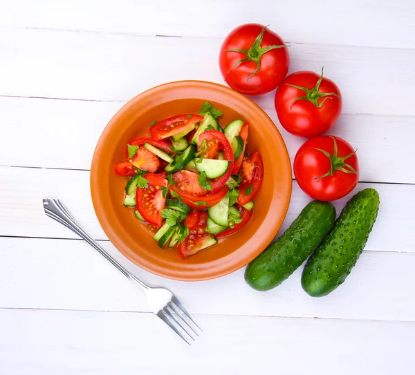 Ensalada fresca con tomates y pepinos sobre fondo de madera blanca —  Fotos de Stock