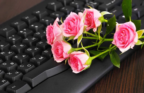 粉红色玫瑰上键盘特写的互联网通信 — 图库照片