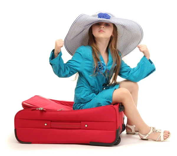 Portrait of little girl on travel case with hat isolated on white — Stock Photo, Image