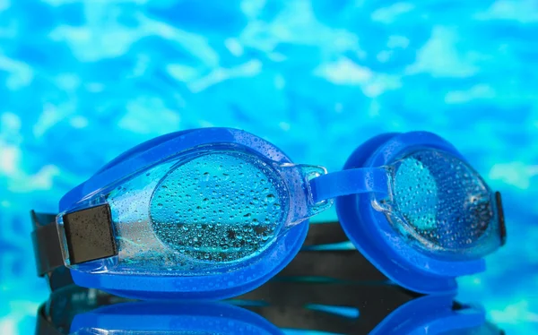 Modré plavat brýle s kapkami na pozadí modré moře — Stock fotografie