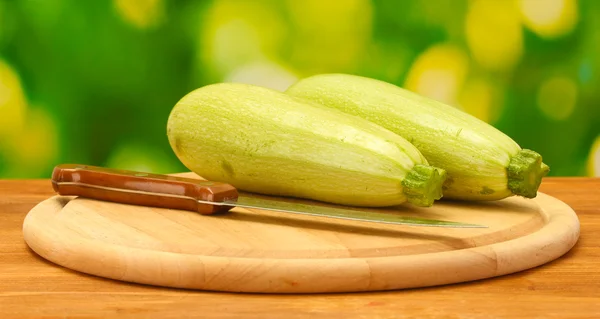 Squash on a cutting board on wooden table on green background close-up — Stock Photo, Image