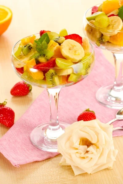 Salade de fruits frais et fraises sur table en bois — Photo