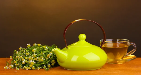 茶壶和洋甘菊茶棕色背景上的木桌上的杯子 — 图库照片